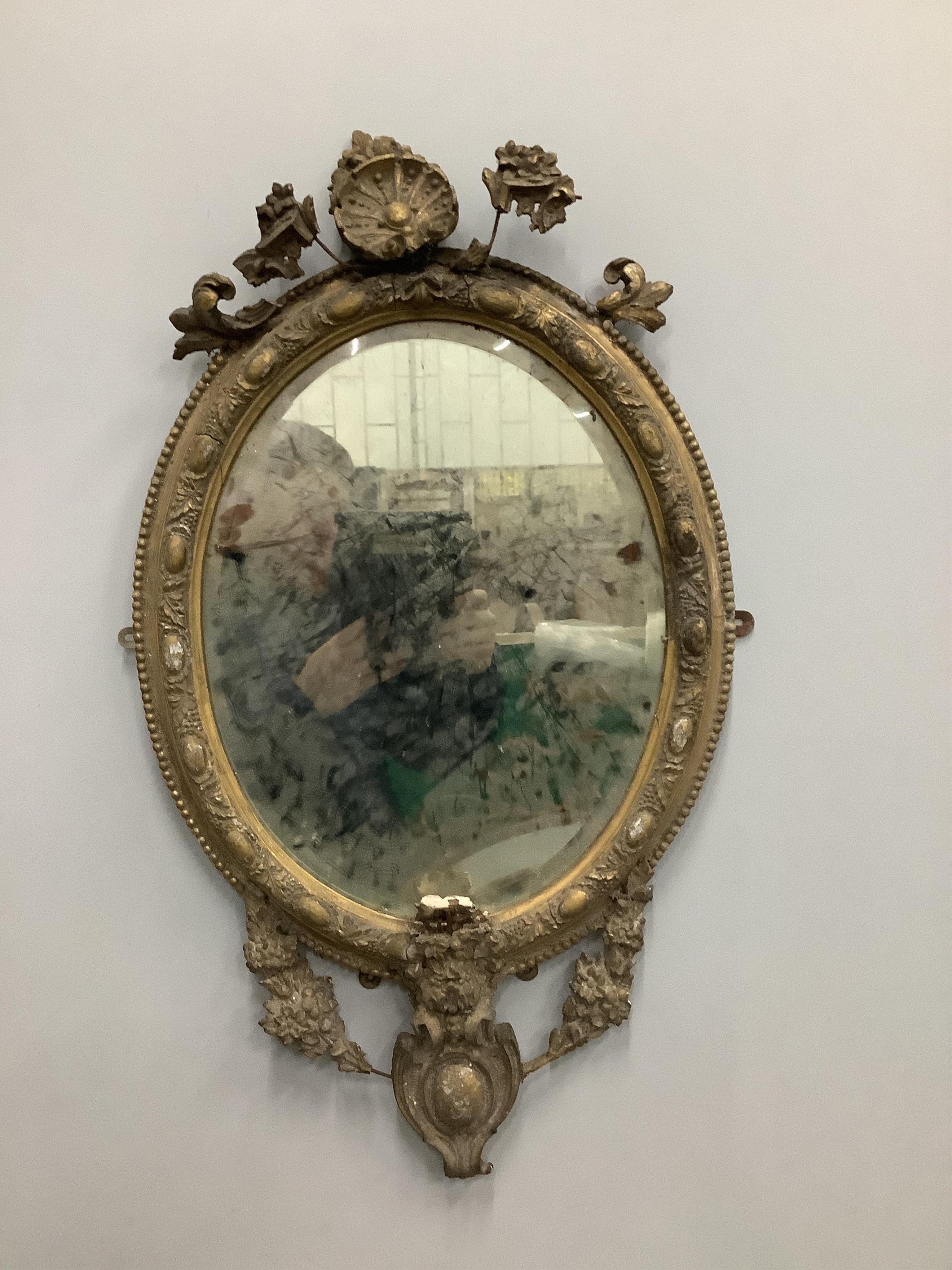 A pair of Victorian oval giltwood and gesso wall mirrors, in need of restoration, width 45cm, height 75cm. Condition - poor, in need of restoration